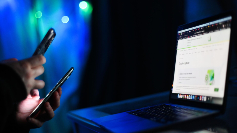 Мужчина держит в руках мобильные телефоны